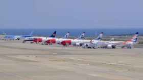 Varios aviones estacionados en un aeropuerto.