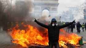 Un manifestante se para frente a una barricada en llamas durante la manifestación de los 'chalecos amarillos' en París.