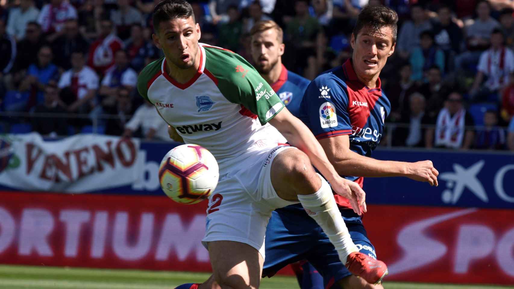Calleri controla el balón ante la oposición de Mantovani en el Huesca - Alavés de La Liga