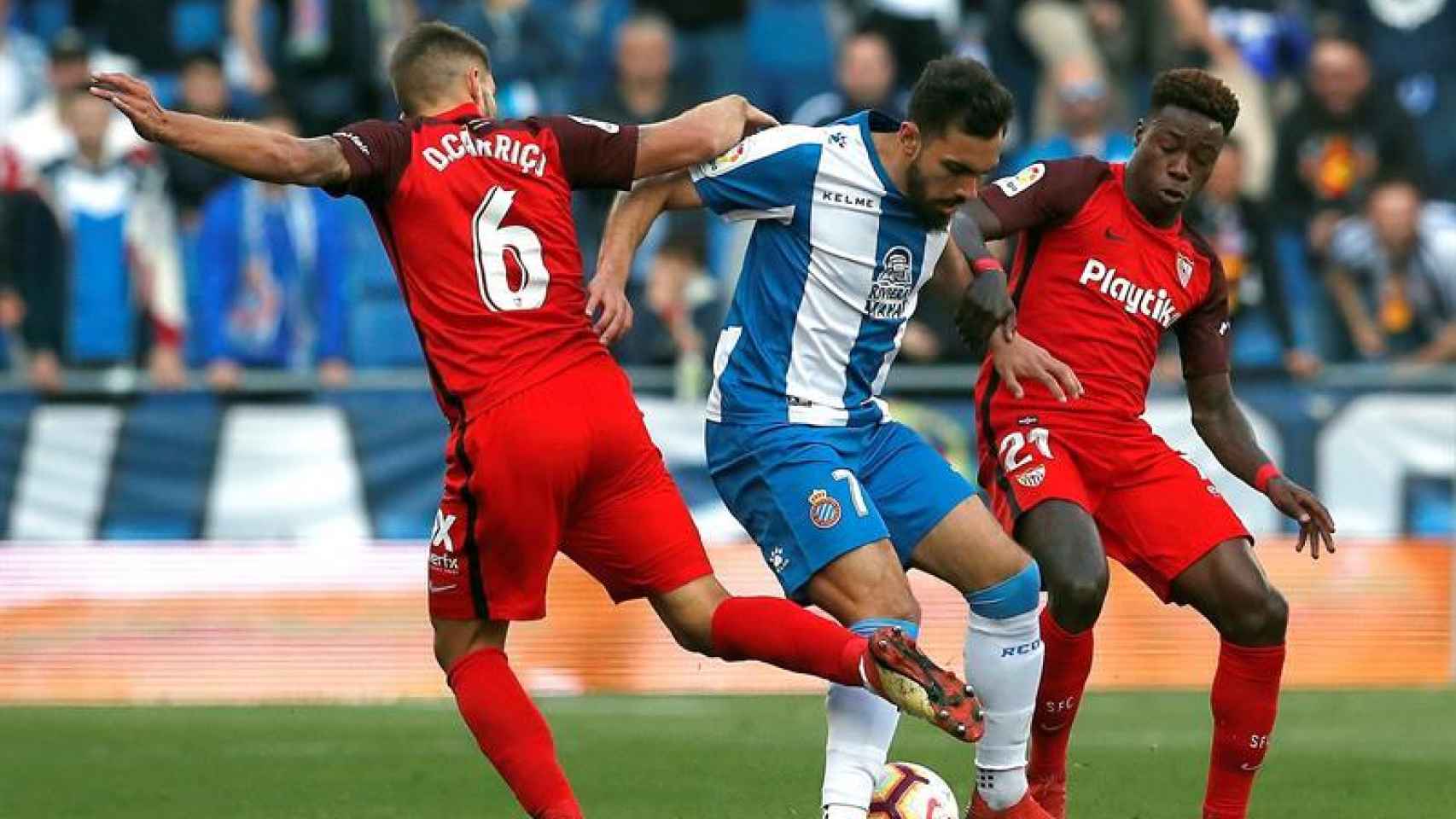 Borja Iglesias intenta llevarse el balón ante los jugadores del Sevilla