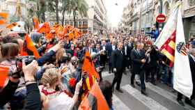 Ricardo Arias, exjugador del Valencia CF, acompañado por el presidente del club, Anil Murthy, portando la bandera del club durante la marcha cívica por el centenario de su fundación