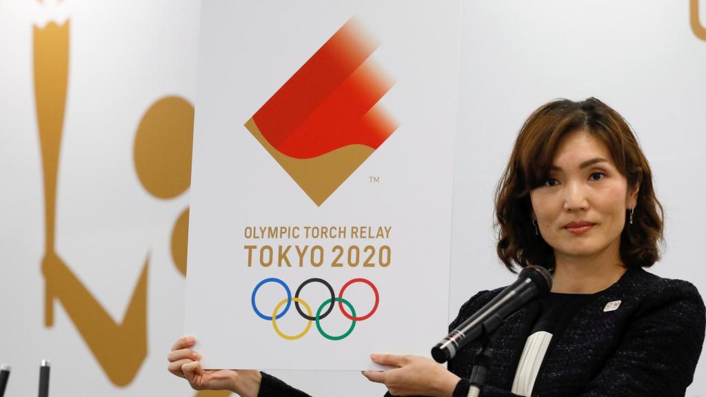 Miko Takeda, miembro del comité de relevos de la antorcha olímpica de los Juegos de Tokio 2020, muestra el emblema durante la ceremonia de presentación