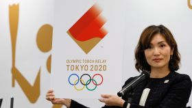 Miko Takeda, miembro del comité de relevos de la antorcha olímpica de los Juegos de Tokio 2020, muestra el emblema durante la ceremonia de presentación