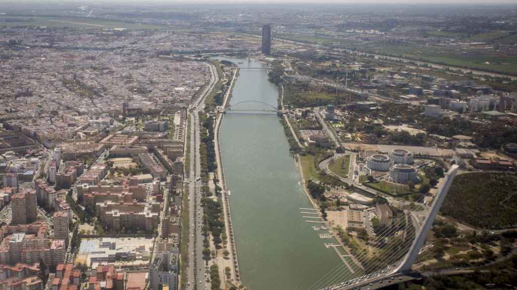 La aeronave sobrevolando Sevilla, a su paso por el río Guadalquivir.