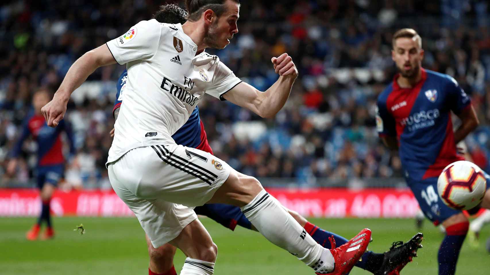 Gareth Bale centra al área frente a un jugador del Huesca
