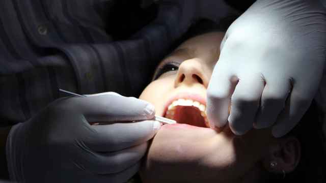 Una paciente es atendida por un dentista.