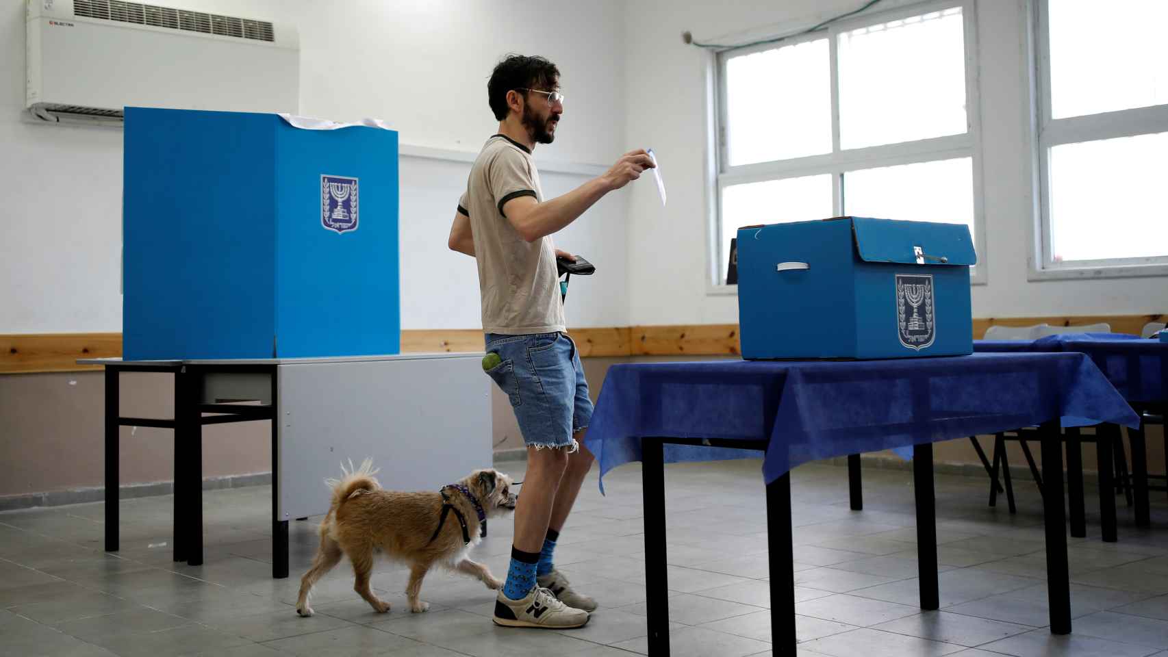Un hombre vota en Israel con su perro.