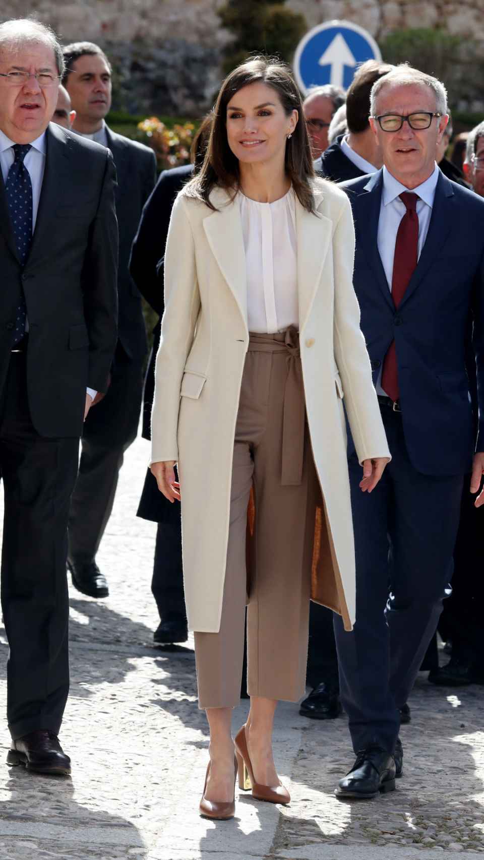 Letizia ha combinado el abrigo blanco con unos pantalones 'paper bag' y una blusa con el cuello fruncido.