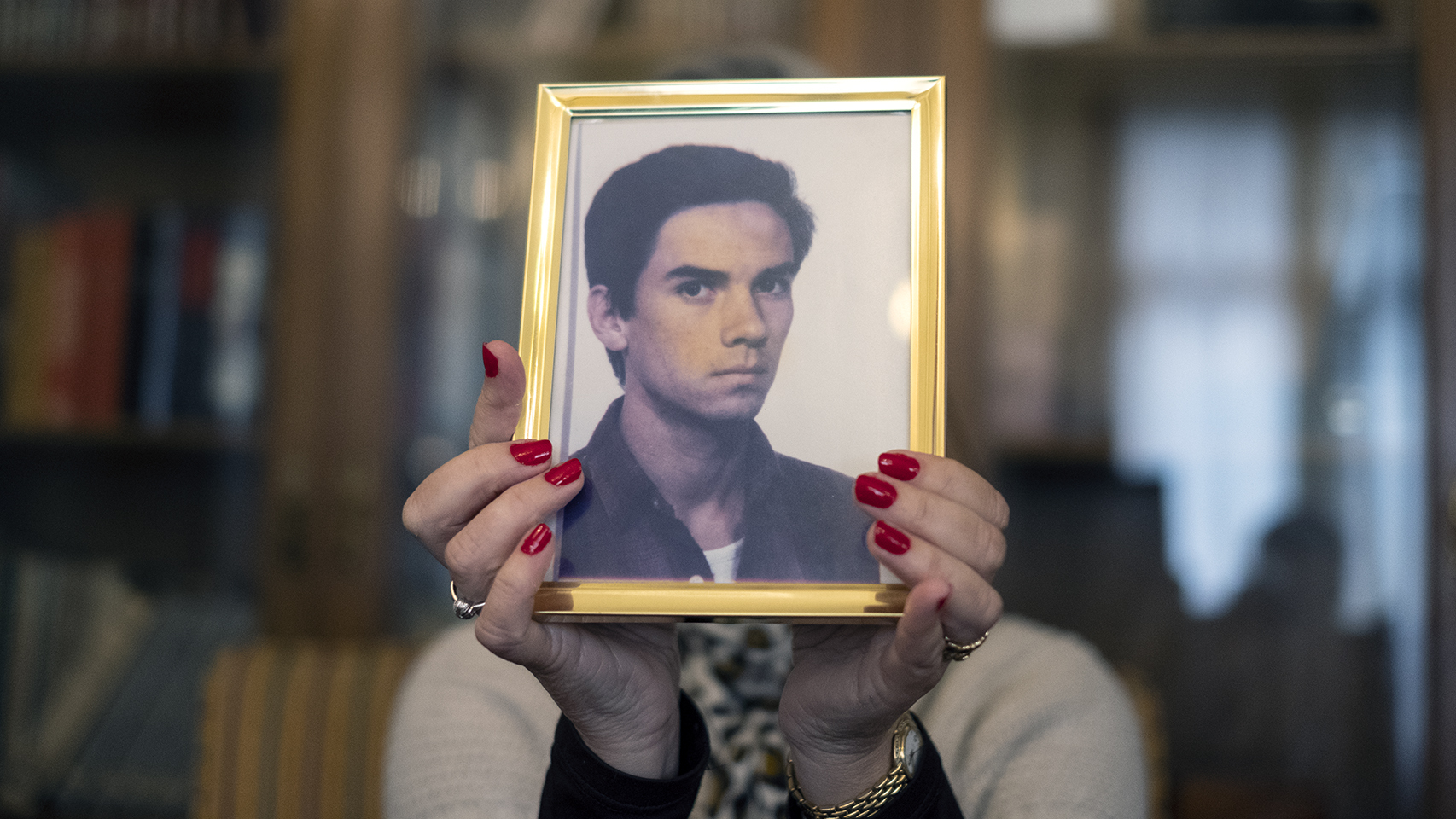 María, hermana de Fernando, sujeta su retrato, tomado 15 días antes del atentado.