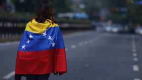 Una manifestante opositora recorre una calle desierta en Caracas