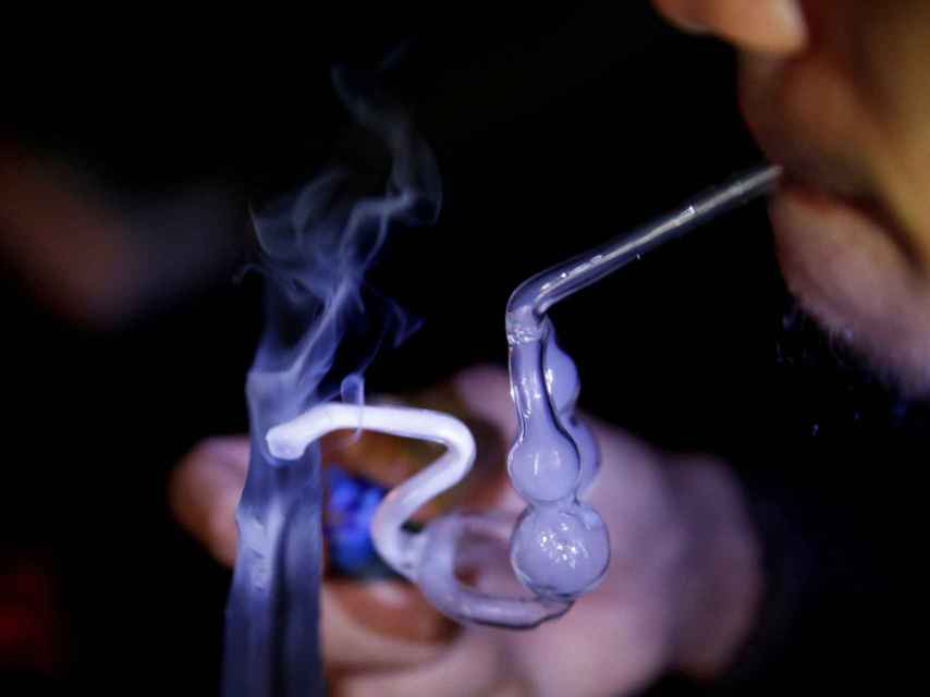 Un consumidor de shabú fumando en una pipa de cristal