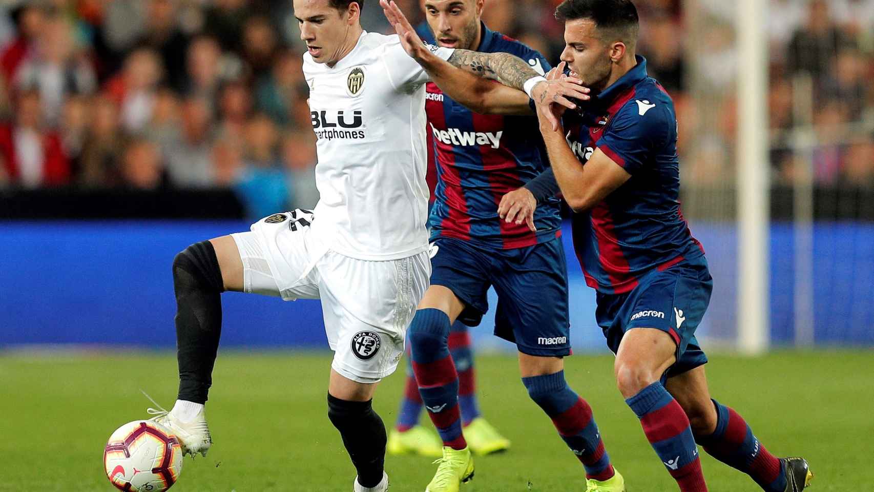 Santi Mina controla el balón ante Rober Pier en el Valencia - Levante de La Liga