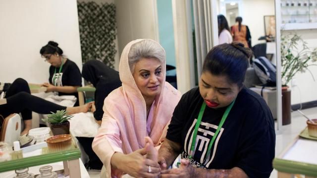 Masarrat Misbah (i), enseña a una se sus estudiantes en su centro de belleza de Lahore el 2 de abril de 2019.