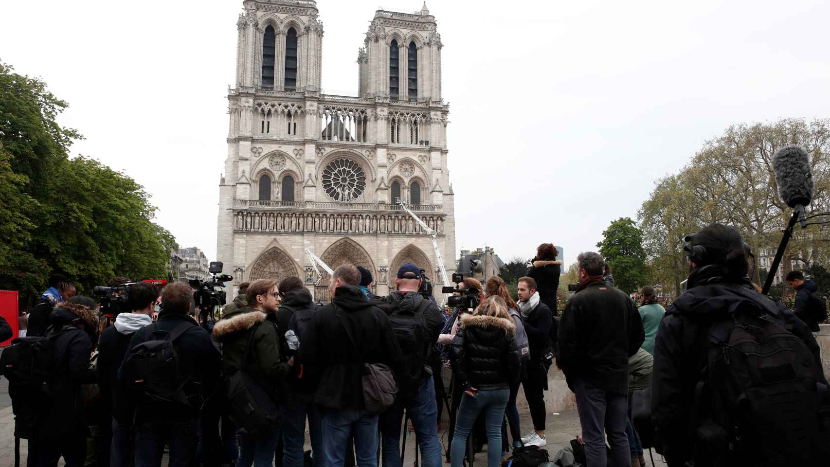 Los periodistas trabajan delante de la fachada de Notre Dame