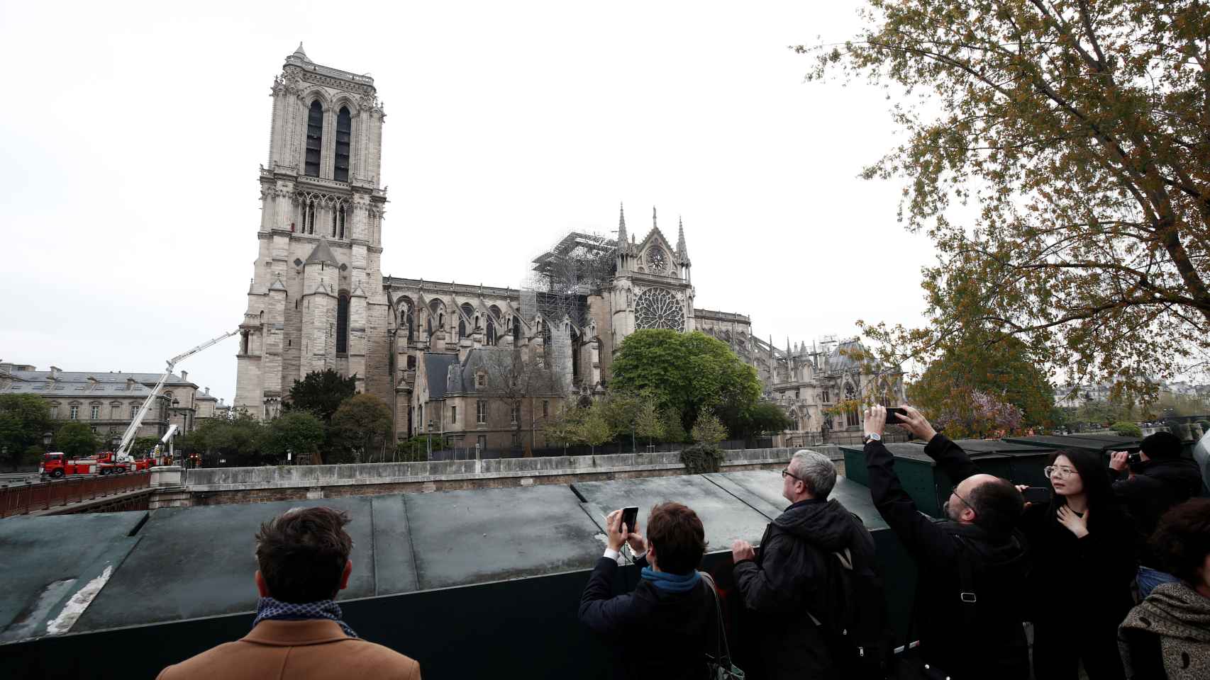 Turistas y parisinos contemplan Notre Dame desde la otra orilla del Sena