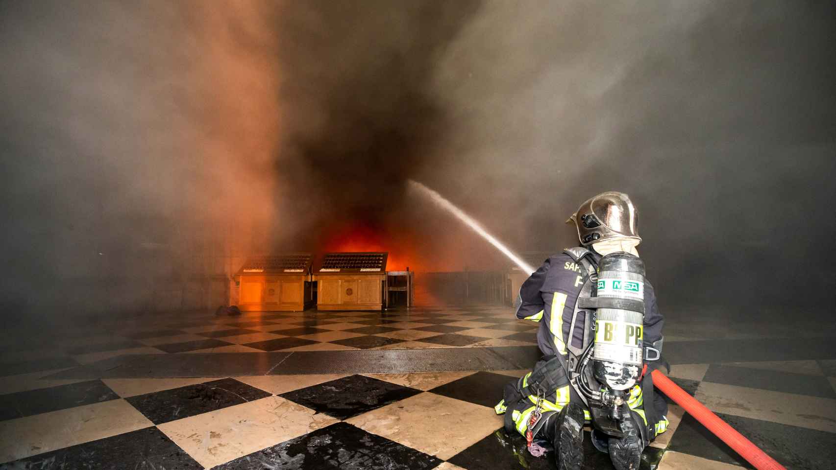Un bombero intentando controlar las llamas en la catedral