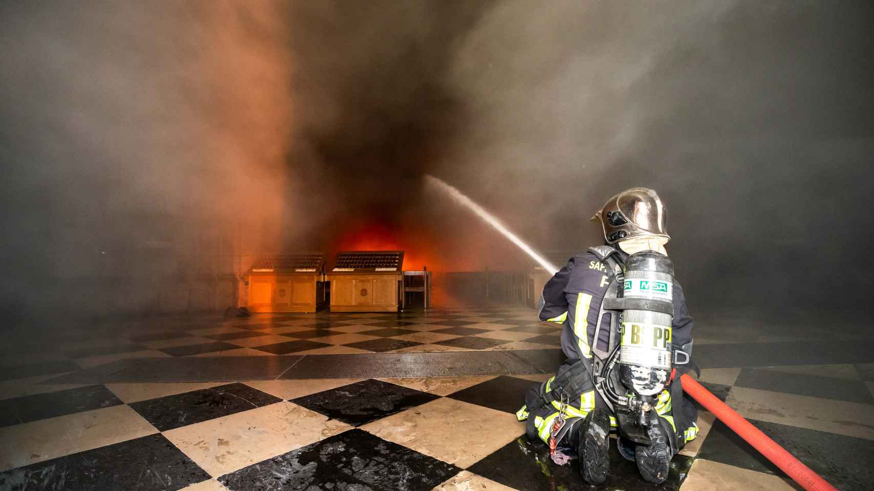 Un bombero intentando controlar las llamas en la catedral
