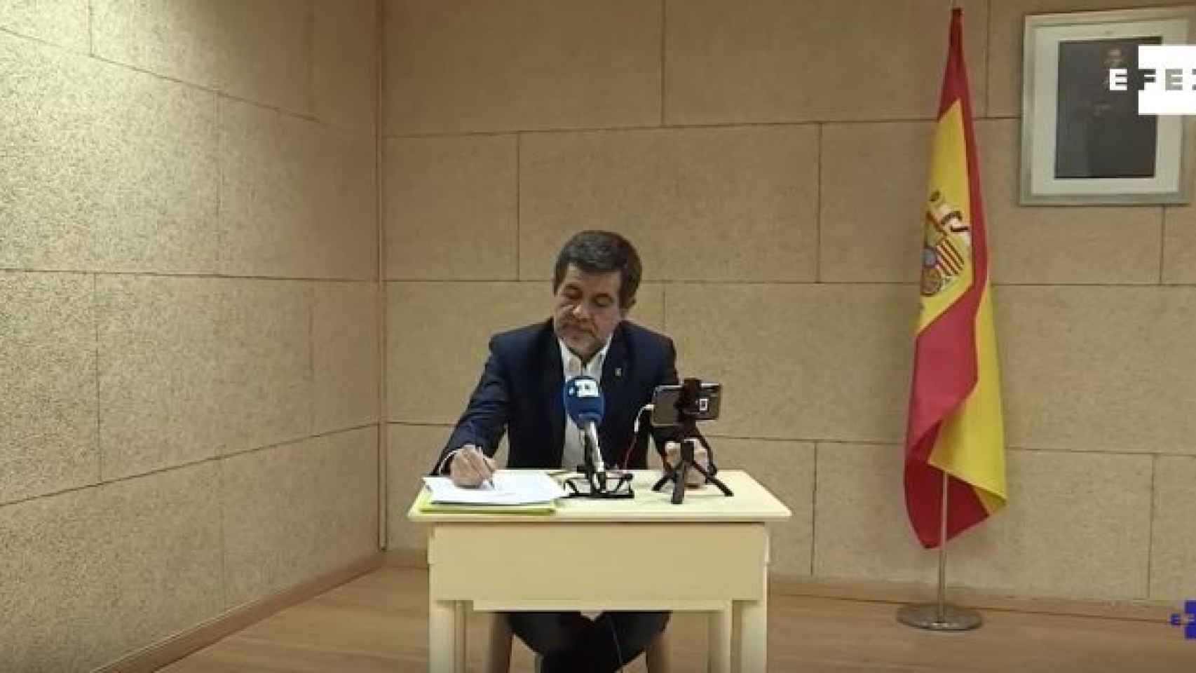 Jordi Sànchez, con una bandera de España de fondo, durante su rueda de prensa en Soto del Real.