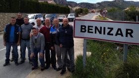 El alcalde pedáneo de Benizar junto al cartel del pueblo y varios vecinos.