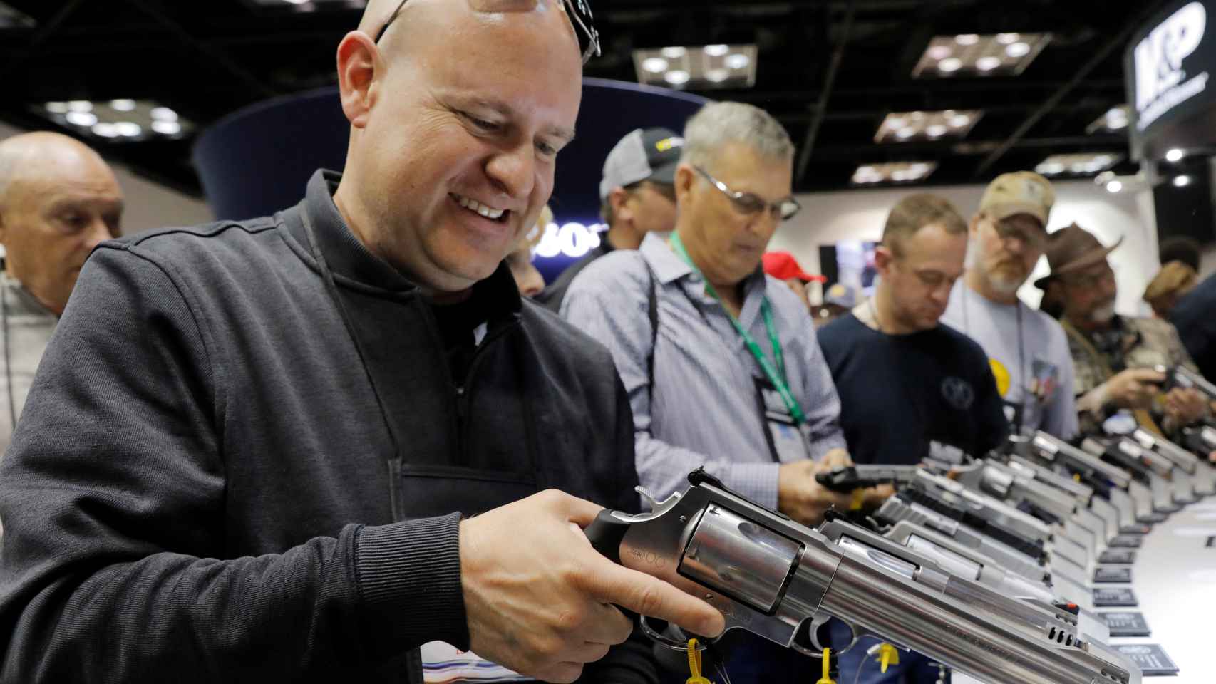 Un hombre maneja un revólver Smith & Wesson, durante la reunión anual de la NRA en Indianápolis.