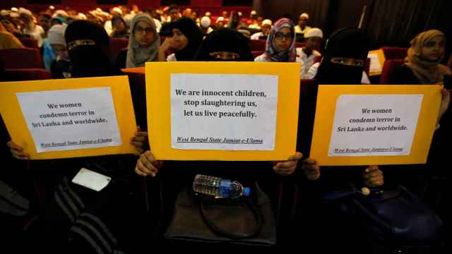 Mujeres musulmanas con carteles que dicen: Somos niños inocentes, dejen de matarnos.