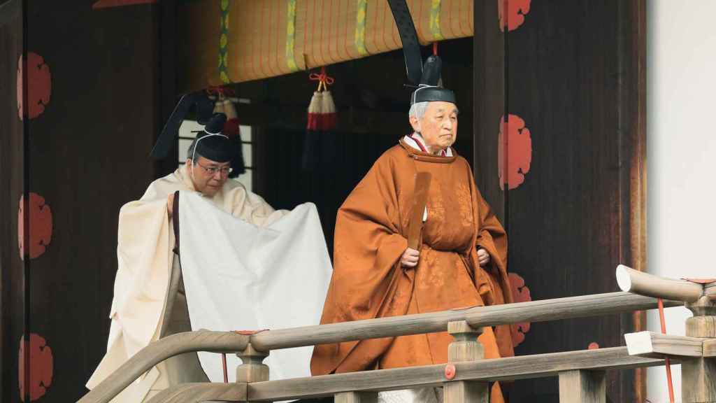 El emperador Akihito caminando hacia el ritual previo a su abdicación.