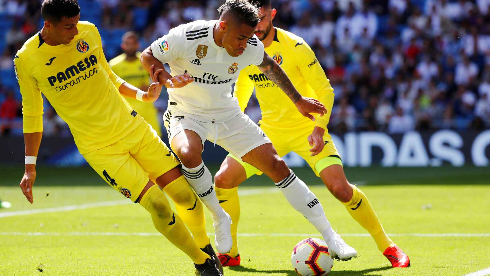 Mariano Díaz intenta controlar el balón entre dos jugadores del Villarreal