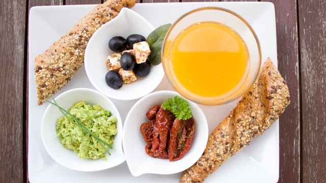 Un desayuno elaborado con zumo de naranja y pan integral.