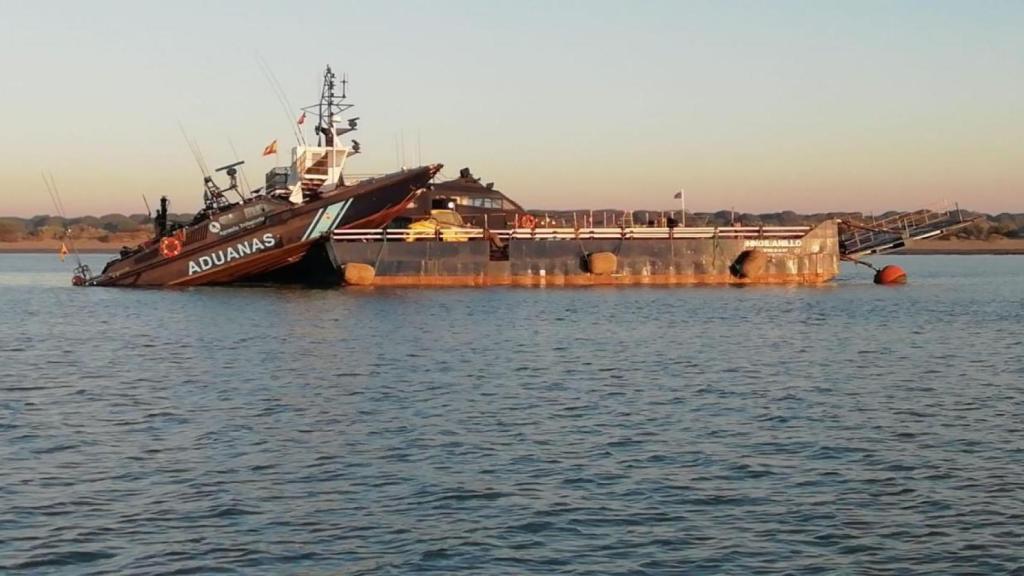 El barco 'Águila 2' de Vigilancia Aduanera, encallado en una gabarra en un operativo en el Guadalquivir.