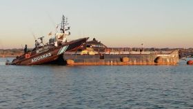 El barco 'Águila 2' de Vigilancia Aduanera, encallado en una gabarra en un operativo en el Guadalquivir.