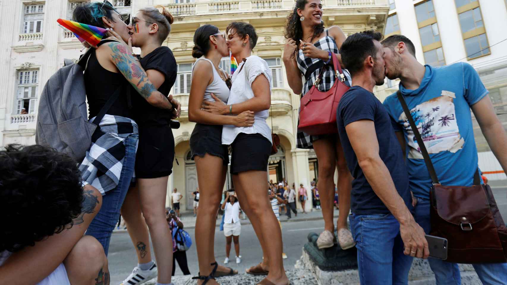 Varias parejas se besan en la marcha LGTB