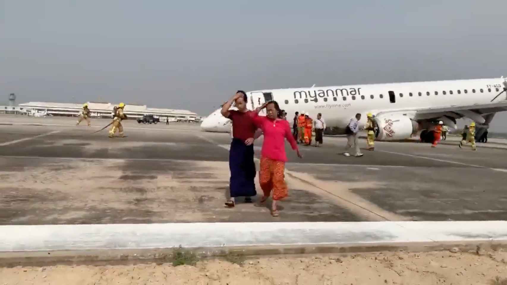 Dos pasajeros salen del avión en el aeropuerto de Mandalay.