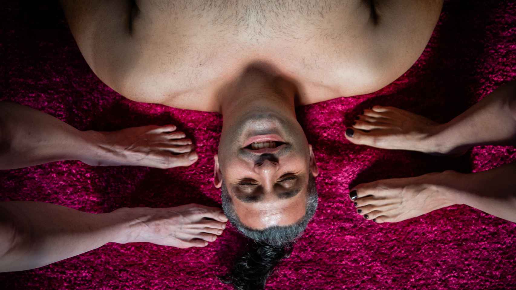 José, descansa sobre una alfombra, rodeado de pies femeninos.