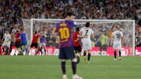 Leo Messi decaído mientras los jugadores del Valencia celebran la victoria