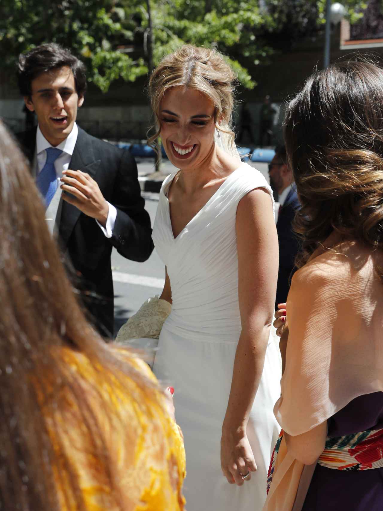 La emocionada novia llega a la puerta de la iglesia, donde la reciben sus damas de honor.