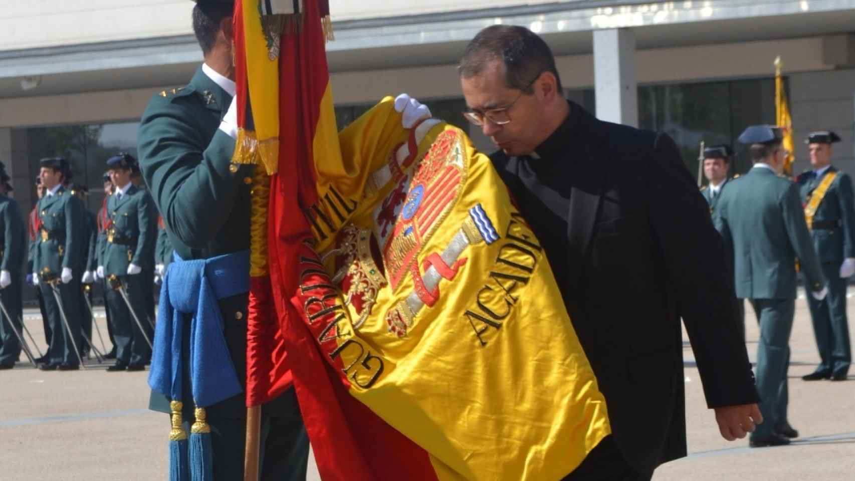 Pablo besa la bandera durante un acto de la Guardia Civil... pero ya siendo sacerdote.