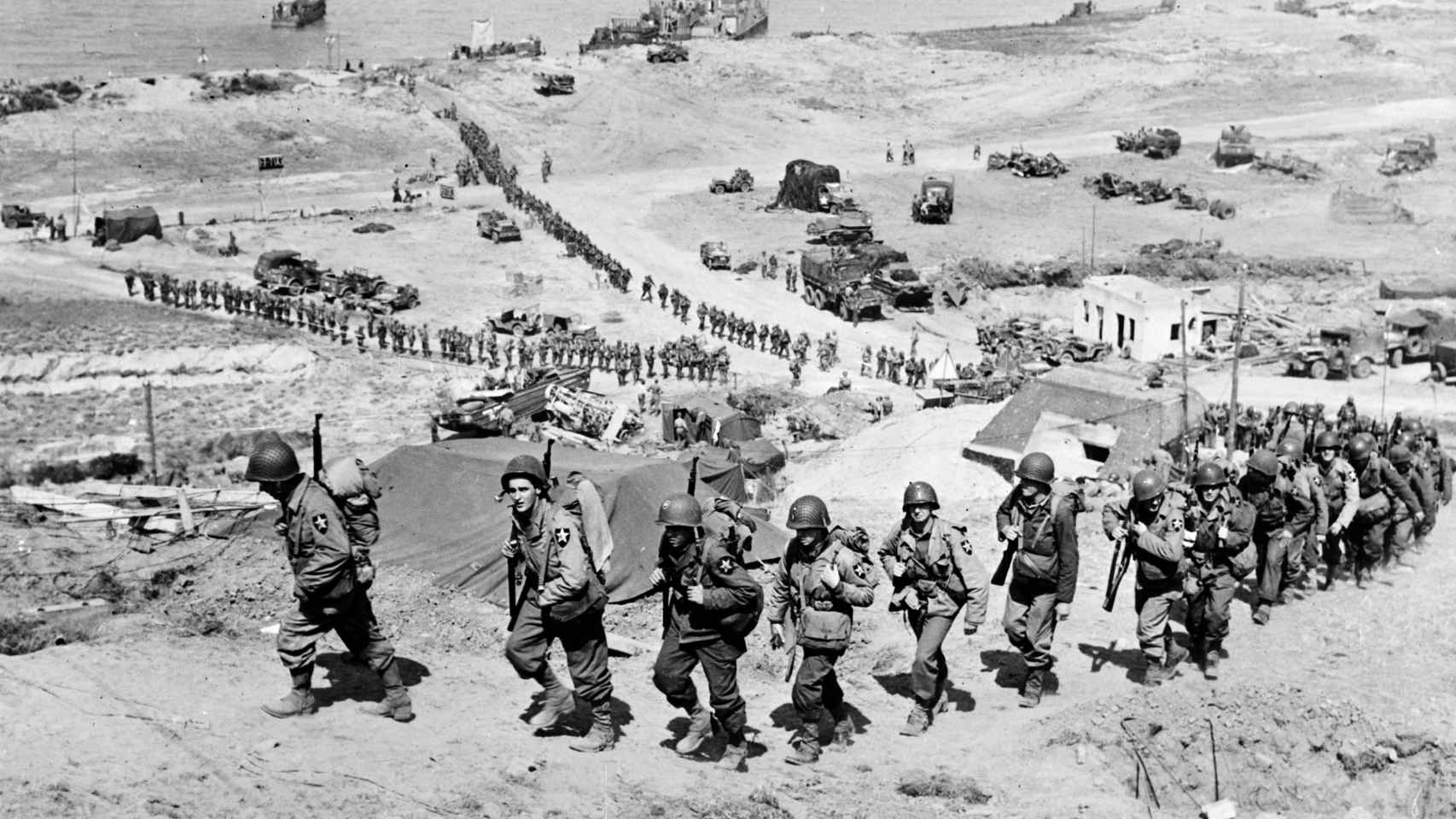 Tropas estadounidenses tras desembarcar en Normandía pasan al lado de un búnker alemán.