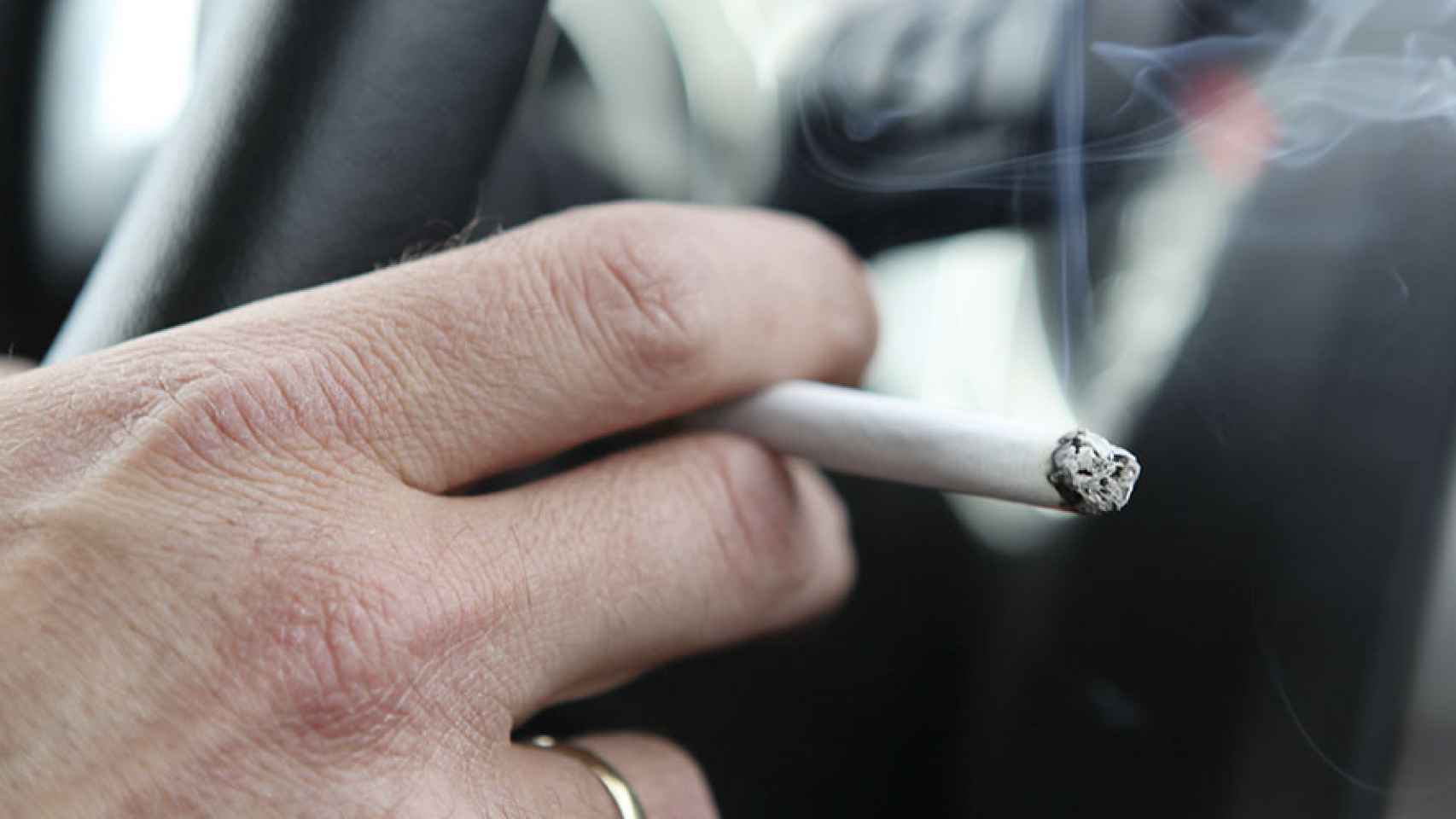 Una persona fumando en un coche.