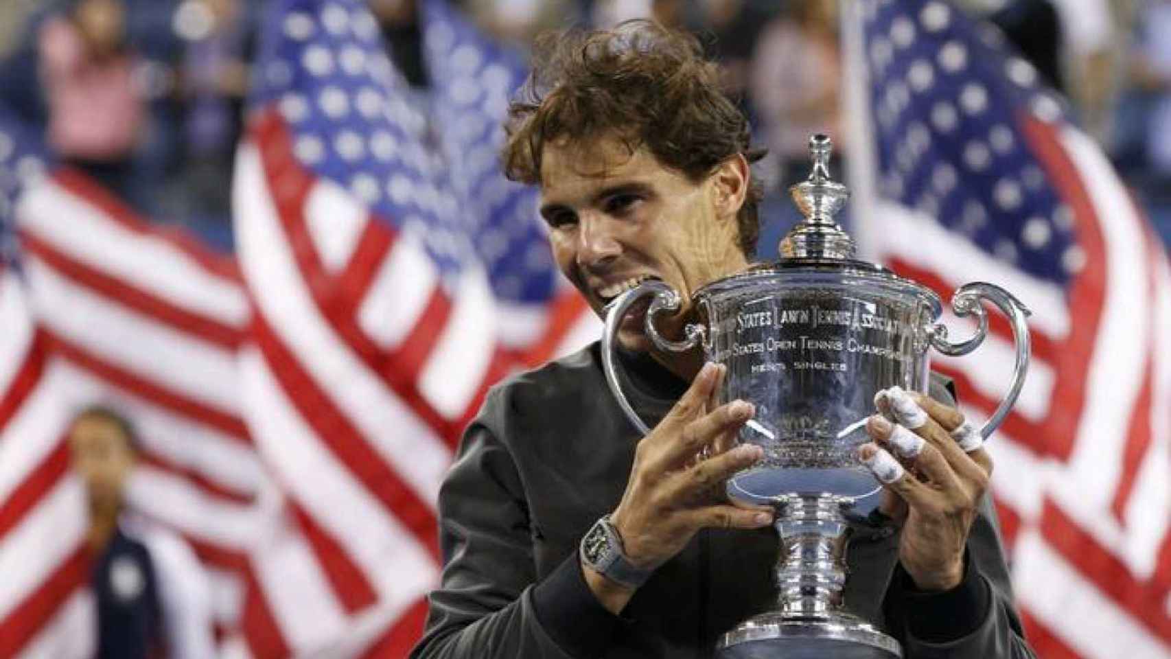 Rafael Nadal celebra su título en el US Open 2013 con su tradicional gesto de morder el trofeo