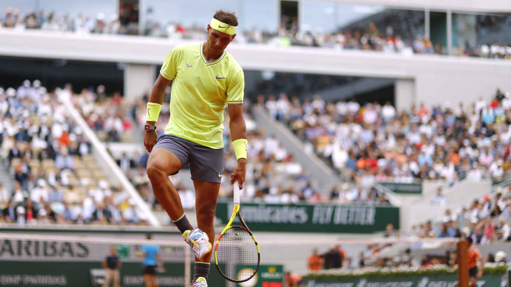 Rafael Nadal golpea sus zapatillas para retirar la tierra pegada a ellas