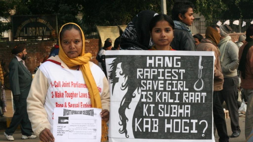 Dos mujeres piden pena de muerte para los violadores durante una protestas en la India. Se puede leer: Colgar al violador salva a la chica.