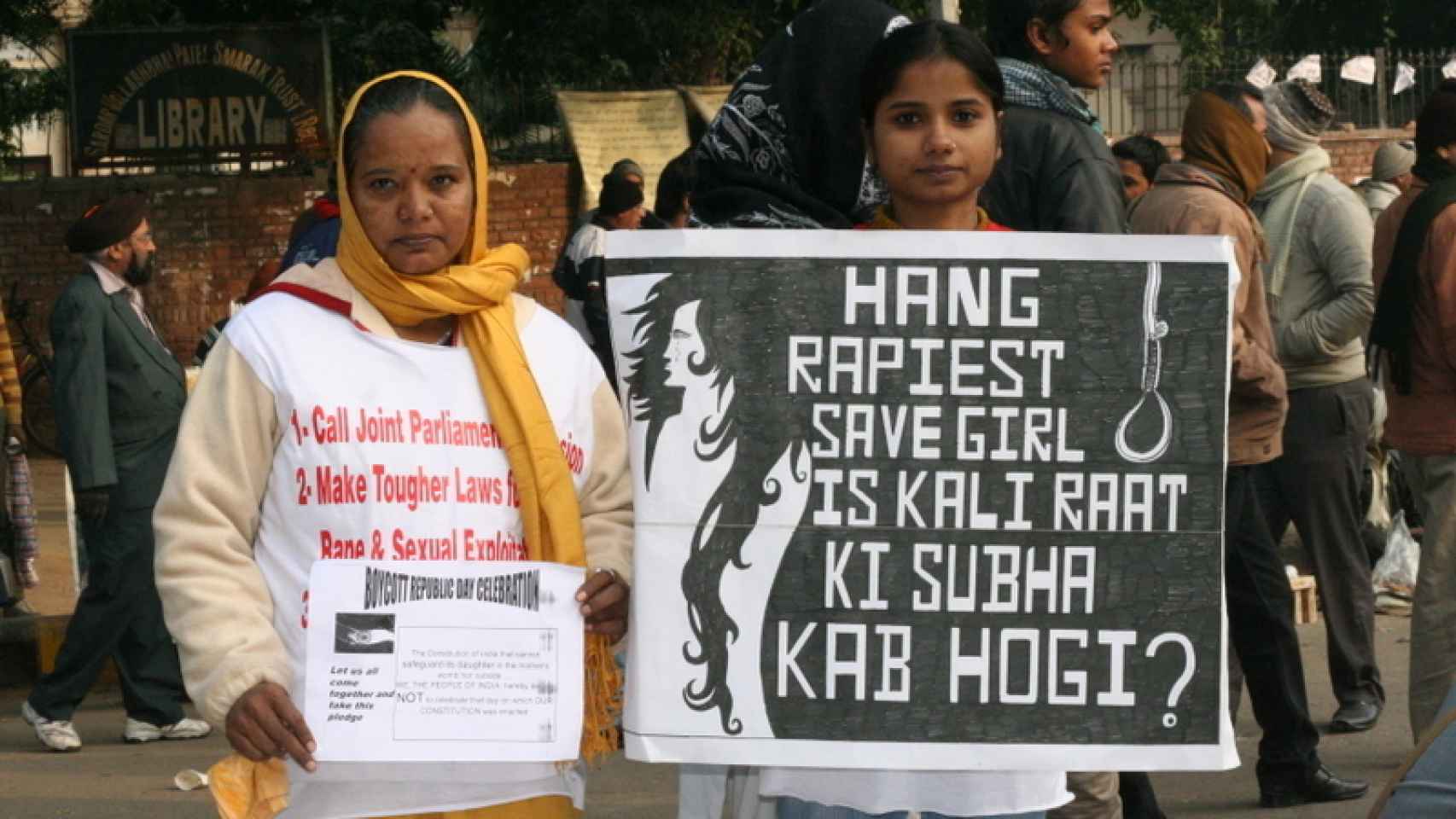 Dos mujeres piden pena de muerte para los violadores durante una protestas en la India. Se puede leer: Colgar al violador salva a la chica.