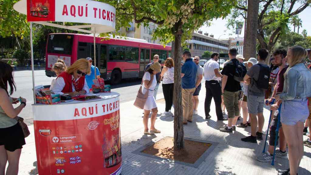 Turistas aguardando para obtener los tickets que les permita subir al autobús turístico.