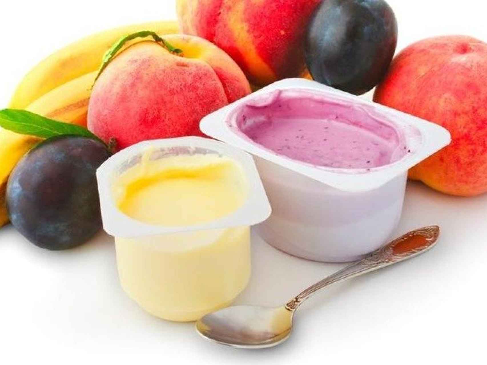 Unos yogures de sabores rodeados de fruta.