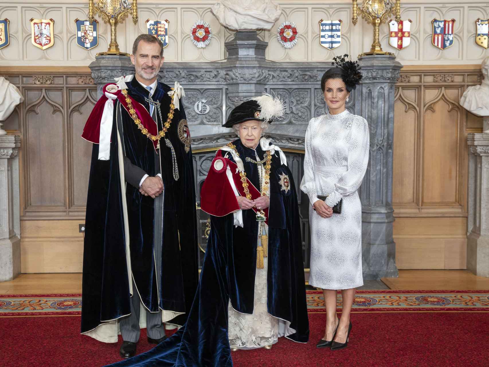 El rey Felipe, la reina Isabel II de Inglaterra y la reina Letizia, con vestido de la firma sevillana Cherubina.