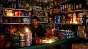 Un vendedor utiliza velas para iluminar su tienda durante el apagón.