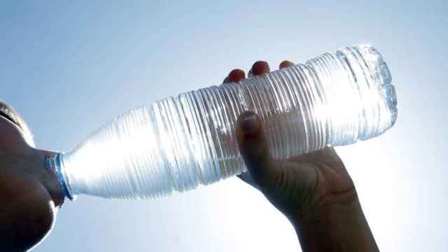 Una persona bebe agua de una botella
