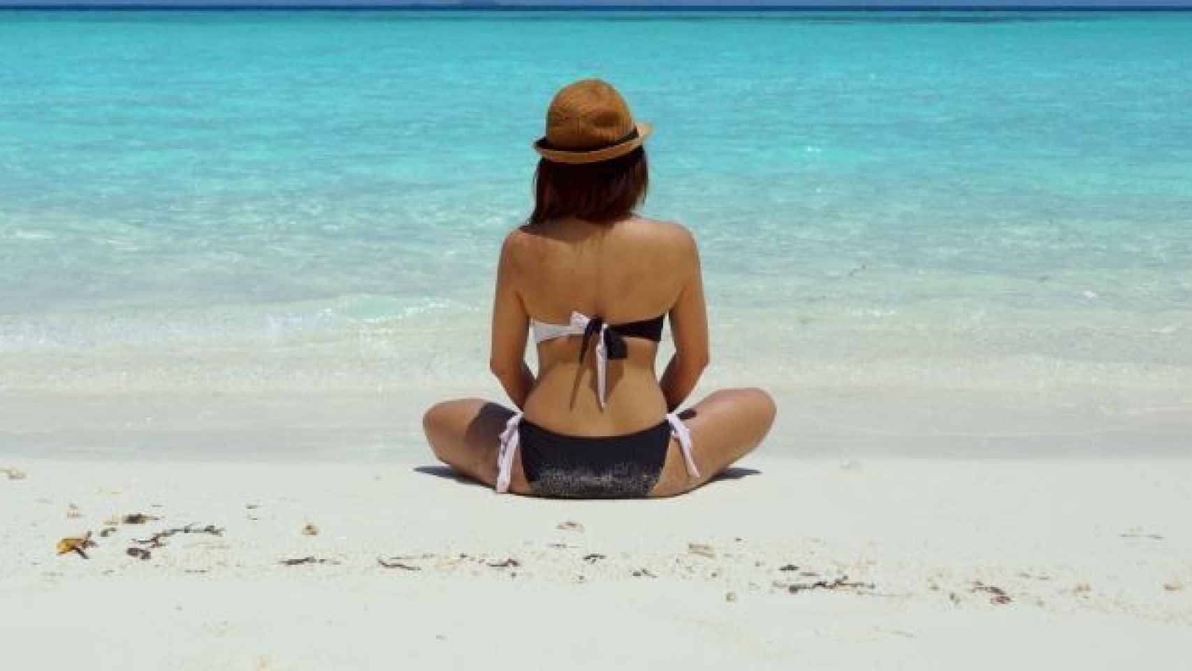 Mujer toma el sol en la playa.