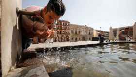 Un joven se refresca en la fuente del patio de los naranjos de la mezquita catedral de Córdoba este sábado. Salas /EFE