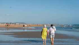 Una pareja pasea por la playa